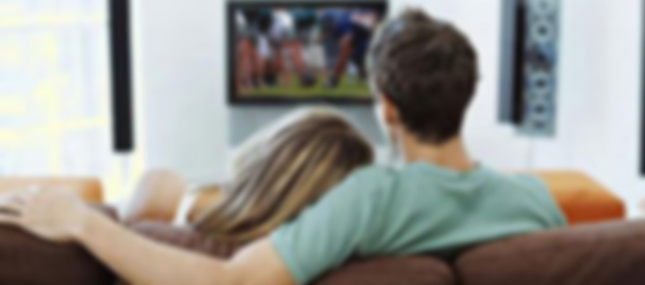 Dad and Mom watching football with baby