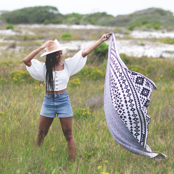 Model holding up the sand-free beach towel